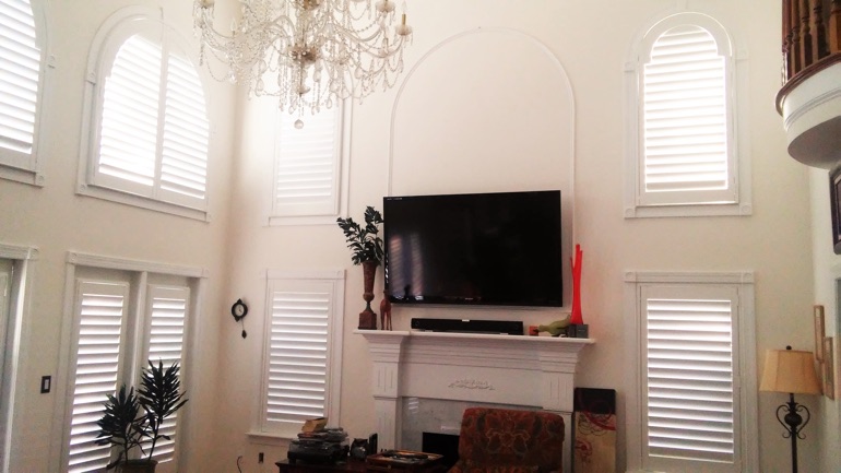 Boston great room with mounted television and high-ceiling windows.